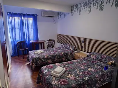 a hotel room with two beds and a table and chairs at Casa la Abuela in Siete Aguas
