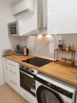 a kitchen with a stove top oven next to a washing machine at GO&REST Apartments in Valencia