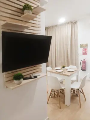 a living room with a tv and a table with chairs at GO&REST Apartments in Valencia