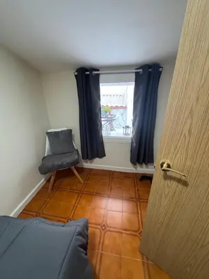 a room with a window and a chair and a door at Casa Alan in Burriana
