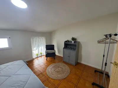 a bedroom with a bed and a chair and a television at Casa Alan in Burriana