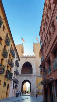 a building with an arch in the middle of a street at Rooms Ciudad Bella in Valencia