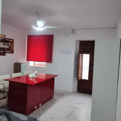 a room with a red counter and a red wall at Rooms Ciudad Bella in Valencia