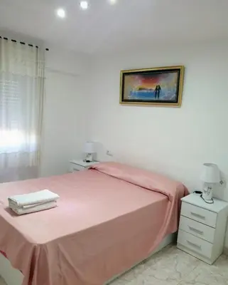 a bedroom with a pink bed and a picture on the wall at Rooms Ciudad Bella in Valencia