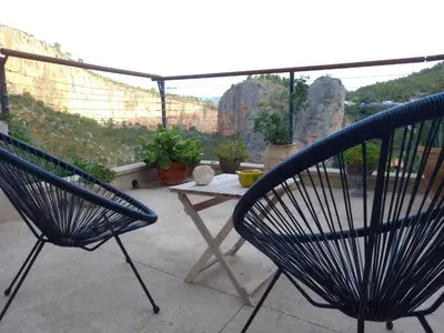 two chairs and a table on a balcony with a view at Casa Rural La Rocha in Chulilla