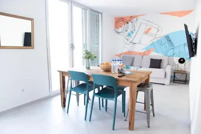 a dining room with a wooden table and blue chairs at VLC Host - Cuber Apartments in Valencia