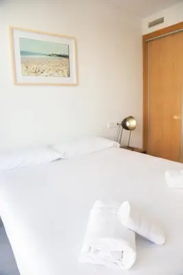 a bedroom with a bed with towels on it at VLC Host - Cuber Apartments in Valencia