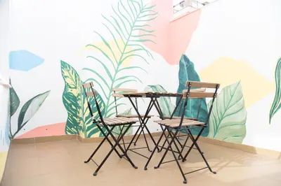 two chairs and a table in front of a wall with plants at VLC Host - Cuber Apartments in Valencia