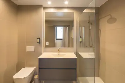 a bathroom with a sink and a toilet and a mirror at Housing Maritim by SharingCo in Valencia