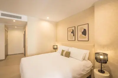 a bedroom with a white bed and two pictures on the wall at Housing Maritim by SharingCo in Valencia