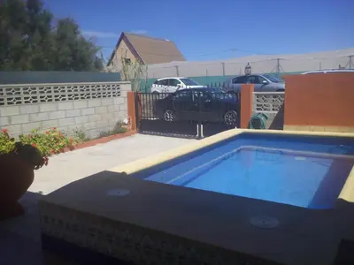 a small swimming pool in a backyard with a car parked at Ca Erik in Mareny Barraquetas