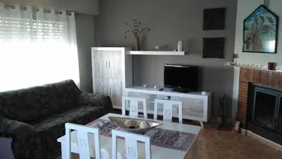 a living room with a couch and a table and a tv at Ca Erik in Mareny Barraquetas