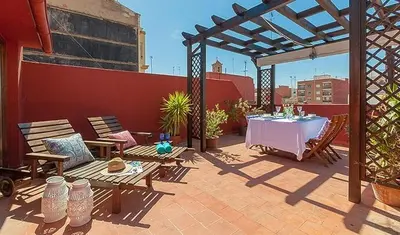 a patio with a table and chairs on a roof at Beautiful House with terrace in Valencia