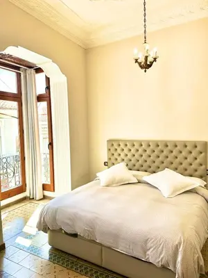 a bedroom with a large bed with a chandelier at Beautiful House with terrace in Valencia
