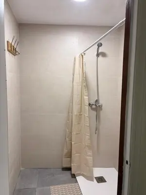 a shower with a shower curtain in a bathroom at LITTLE Hostel in Puerto de Sagunto