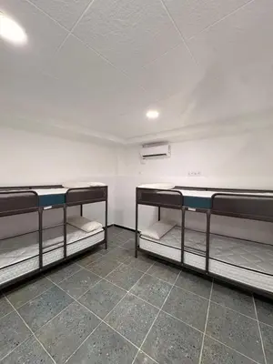 three bunk beds in a room with a white wall at LITTLE Hostel in Puerto de Sagunto