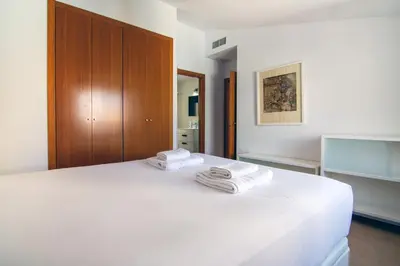 a bedroom with a white bed with towels on it at VLC Host - Poeta Llombart in Valencia