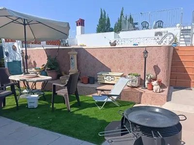 a patio with a grill and chairs and an umbrella at Beautiful bedroom Country Villa with swimming pool in Lliria