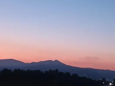 a sunset with mountains in the background at El Faro de Nules in Mascarell