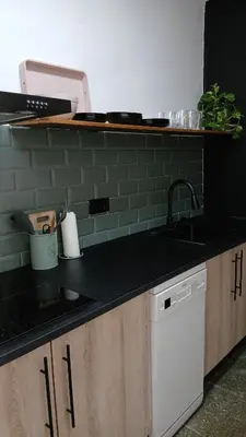 a kitchen with a black counter top and a sink at El Faro de Nules in Mascarell