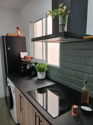 a kitchen with a black counter top with a window at El Faro de Nules in Mascarell