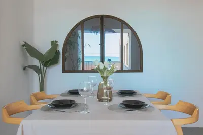 a dining room table with a white table cloth and glasses at Faro de Nules in Mascarell