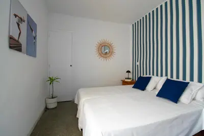 a bedroom with a large white bed with blue pillows at Faro de Nules in Mascarell