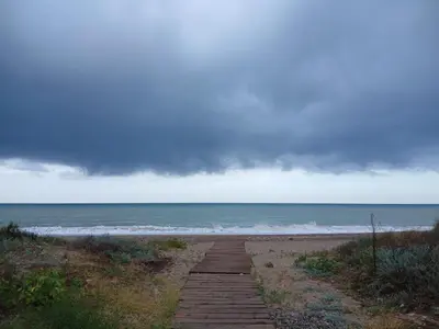 a walkway to the beach with the ocean in the background at Faro de Nules in Mascarell