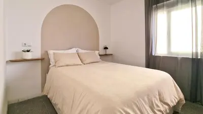 a bedroom with a white bed with a window at Faro de Nules in Mascarell