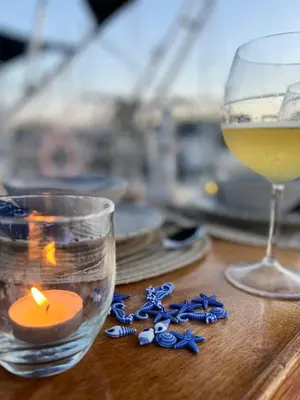 a candle and a glass of wine on a table at Unique Experience in Sailboat! In The 4 Seasons!! B shi in Valencia