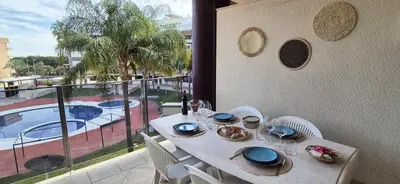 a white table and chairs with a view of a pool at Apartamento Timia OASIS in Canet de Berenguer