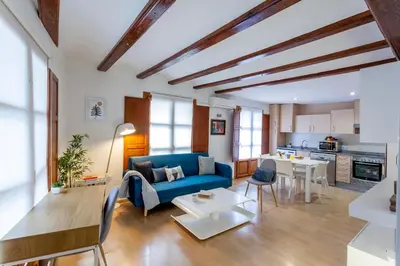 a living room with a blue couch and a kitchen at Apartment 1 bedroom Mercado Central in Valencia