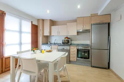 a kitchen with a white table and white chairs at Apartment 1 bedroom Mercado Central in Valencia