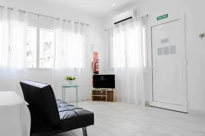 a living room with a black chair and a television at Boutique Loft 1 next to Torres de Serrano in Valencia