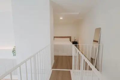 a white room with a bed and a staircase at Exclusivo loft 3 en zona privilegiada en Valencia in Valencia