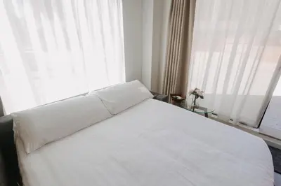 a white bed in a room with a window at Exclusivo loft 3 en zona privilegiada en Valencia in Valencia