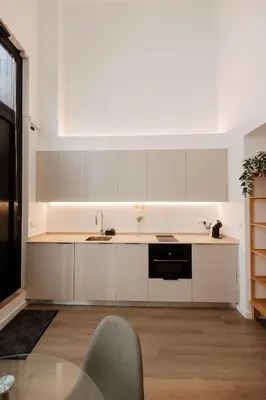 a kitchen with white cabinets and a glass table at Luxury apartment in Valencia in Valencia