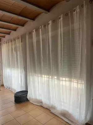 a row of white curtains on a wall at Chalet en la naturaleza in Macastre