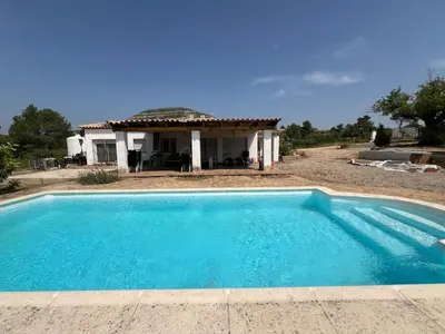 a swimming pool in front of a house at Chalet en la naturaleza in Macastre