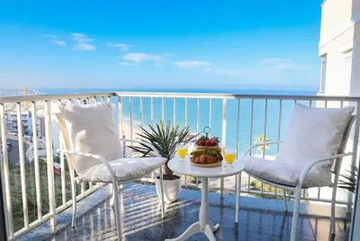 a living room with a couch and a tv and a balcony at Apartment with sea view in Cullera in Faro de Cullera