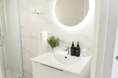 a white bathroom with a sink and a mirror at Apartment with sea view in Cullera in Faro de Cullera