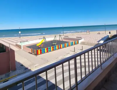 a playground on the beach next to the ocean at De frente al mar in Sueca
