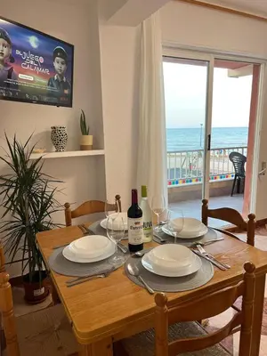 a dining room table with plates and wine glasses at De frente al mar in Sueca