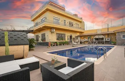 a villa with a swimming pool in front of a house at Villa Naranjos - Sauna - Jacuzzi - Gym - BBQ in Picassent