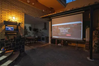 a large projection screen on a brick wall in a room at Villa Naranjos - Sauna - Jacuzzi - Gym - BBQ in Picassent