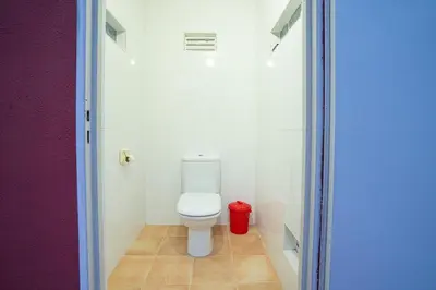 a bathroom with a toilet and a red trash can at Villa Naranjos - Sauna - Jacuzzi - Gym - BBQ in Picassent