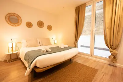 a bedroom with a bed and a large window at Apartamento Familiar En Valencia Centro - Plaza Ayuntamiento in Valencia