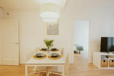 a white dining room with a white table and chairs at Apartamento Familiar En Valencia Centro - Plaza Ayuntamiento in Valencia