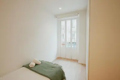 a white room with a bed and a window at Apartamento Familiar En Valencia Centro - Plaza Ayuntamiento in Valencia