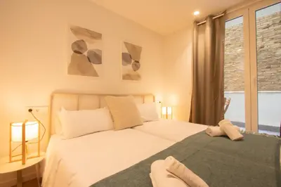 a bedroom with a white bed and a window at Apartamento Familiar En Valencia Centro - Plaza Ayuntamiento in Valencia